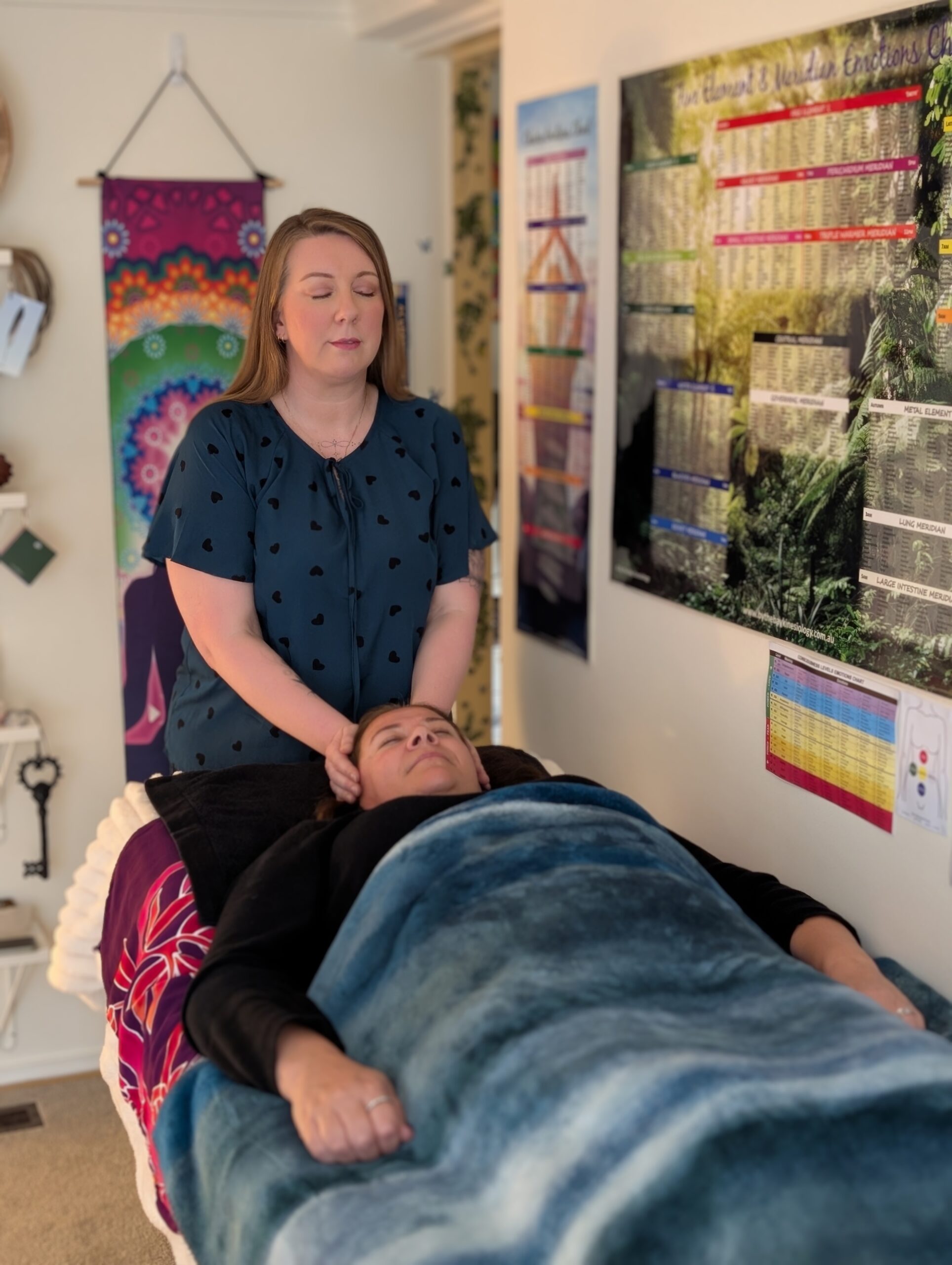 Kath Whitehorn providing a one on one session with a client resting comfortably on a treatment table at Hill Tribe Healing.
